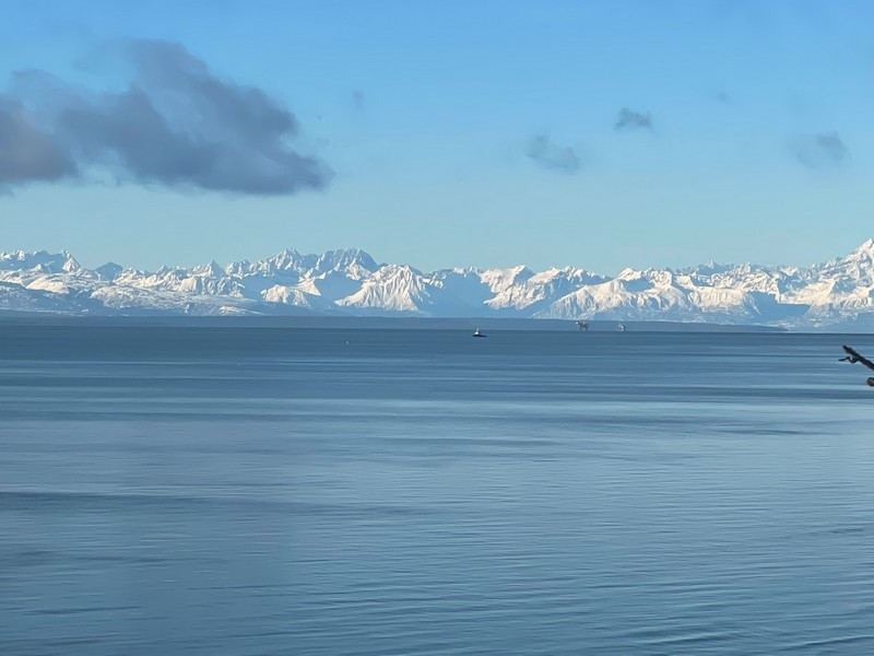 picture of window view of ocean and mountains from living room of mountains across cook inlet